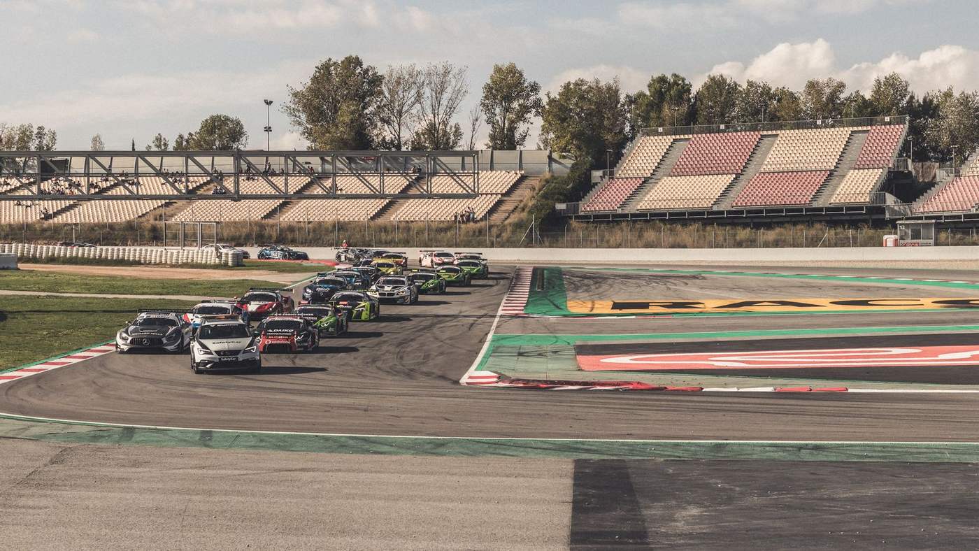 Pelotão de carros de corrida em uma curva de autódromo