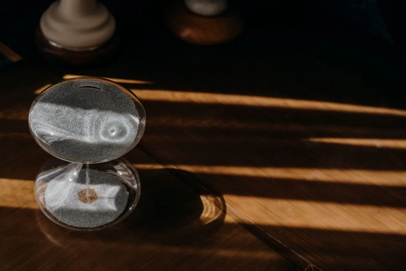 Ampulheta sobre mesa de madeira com a luz da manhã