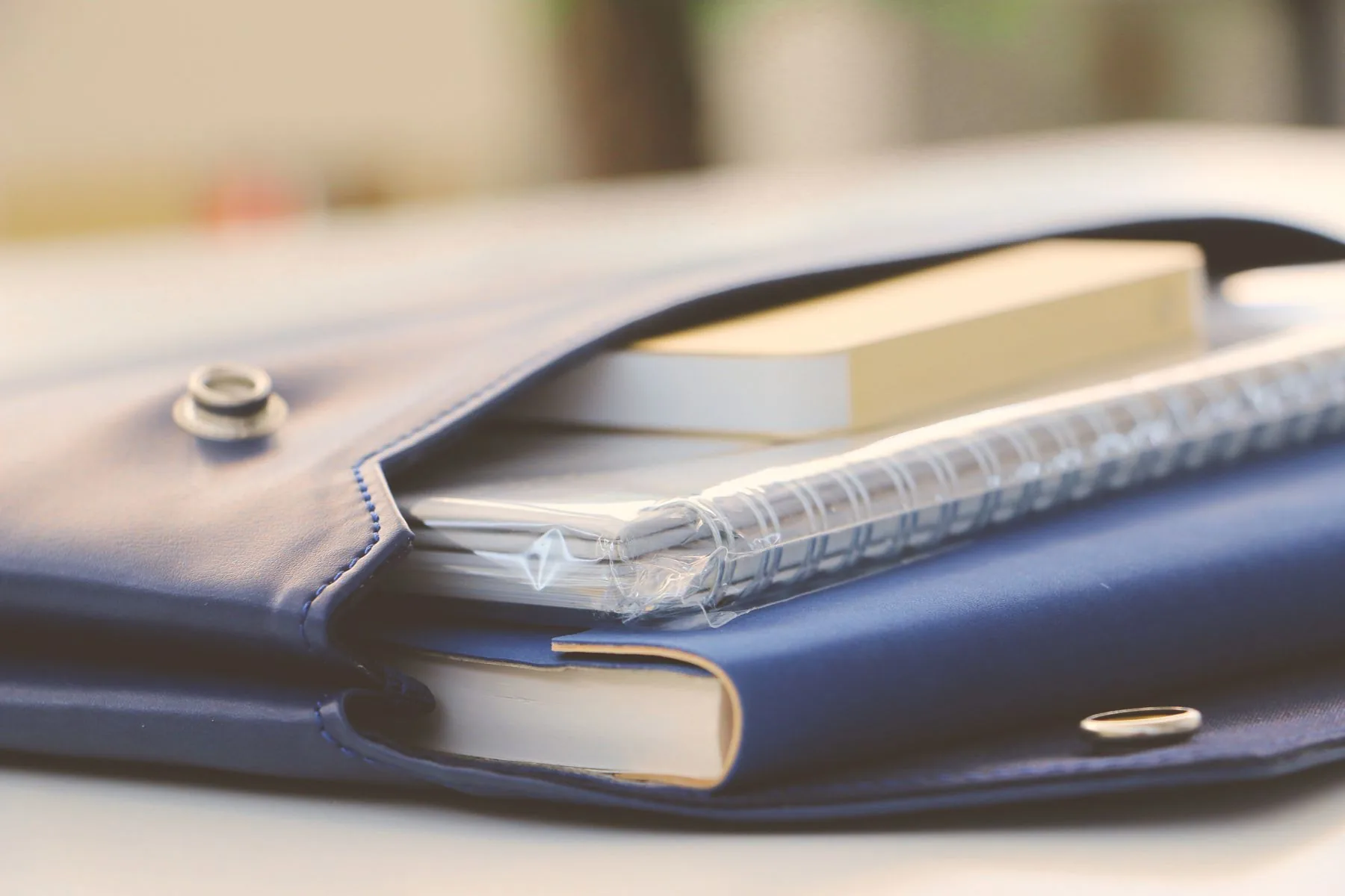 Carteira de couro azul com caderno e caneta