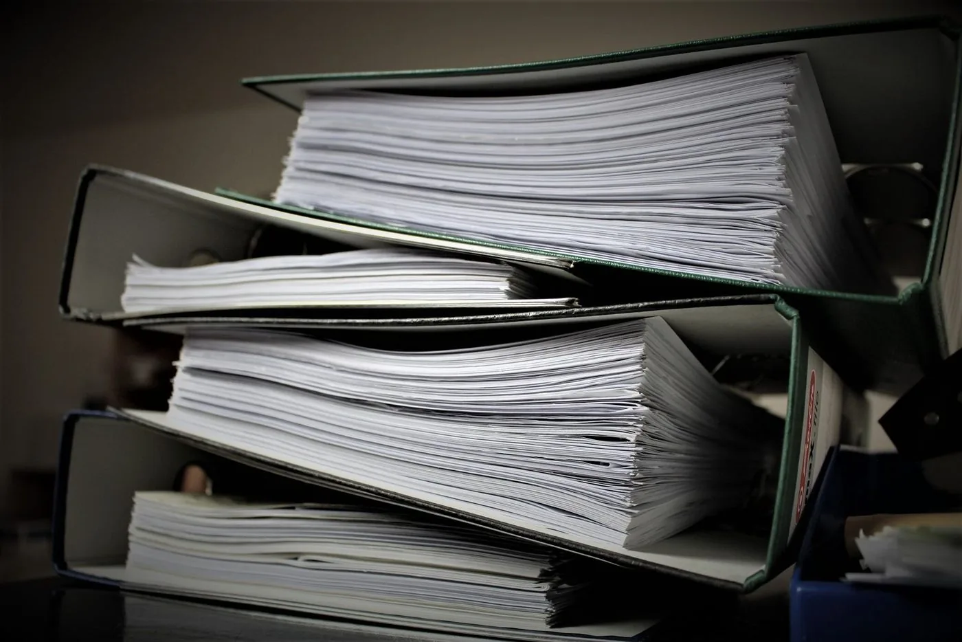 Pastas de arquivo lotadas de documentos sobre a mesa
