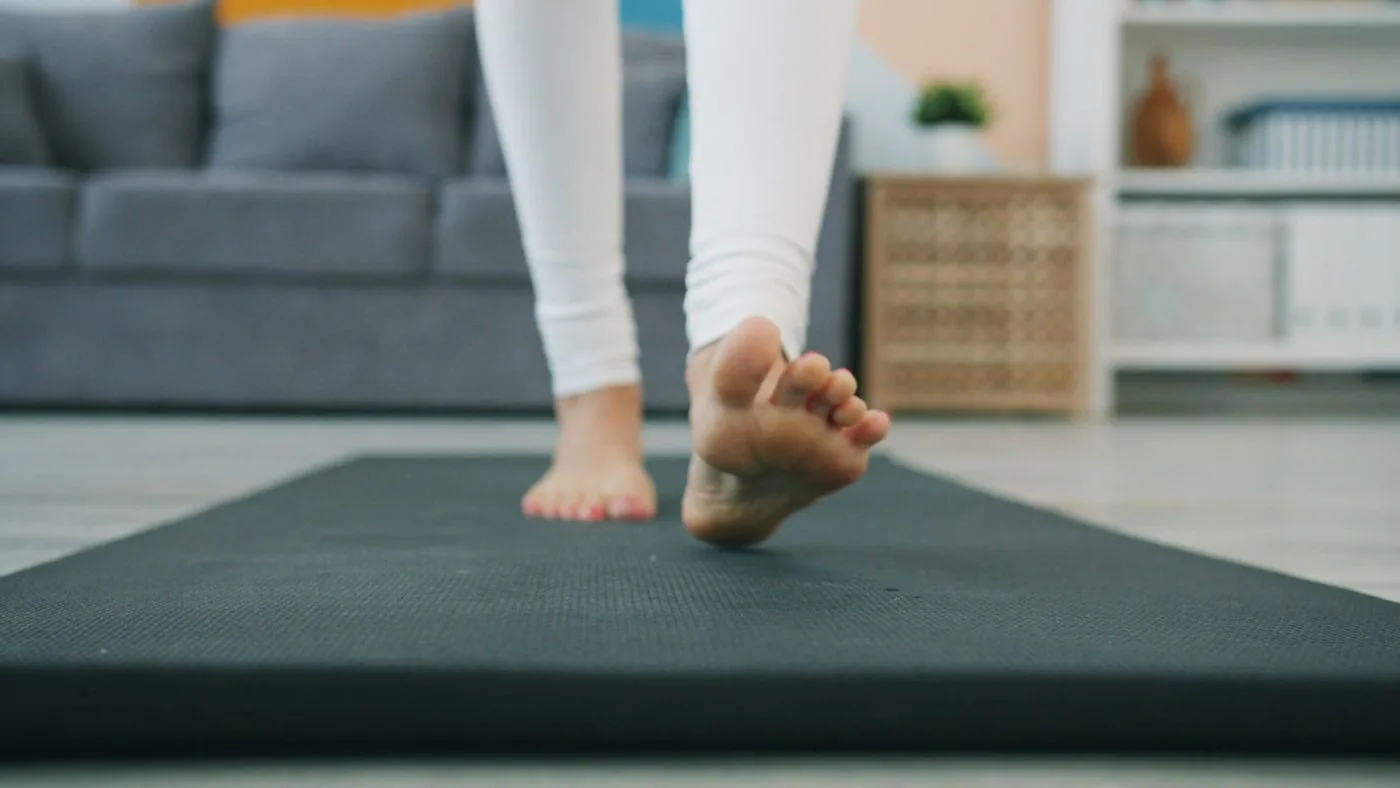 Pés descalços sobre um tapete de yoga